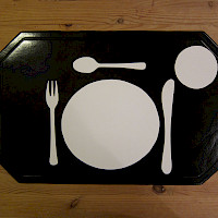 schwarzes Tischset mit aufgeklebtem Essgeschirr-  und Besteck aus weißer Klebefolie